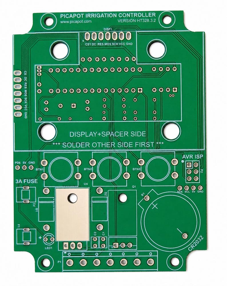 May include: A green printed circuit board for a Picapot irrigation controller, version HT328.3.2. The board features labeled mounting holes, solder pads for buttons, a 3A fuse slot, a CR2032 battery holder area, and text reading DISPLAY+SPACER SIDE.