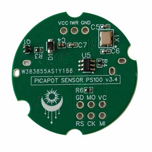 May include: A circular green printed circuit board labeled PICAPOT SENSOR PS100 v3.4 with the serial number W383855AS1Y188. The board features various electronic components, including a central chip, a crystal oscillator, and a white sun and moon graphic.