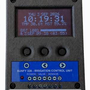May include: A black rectangular irrigation control unit with a digital display showing date, time, temperature, moisture, and battery levels. The unit features three circular buttons, a blue control panel labeled SUNFY 328, and six screw terminals.