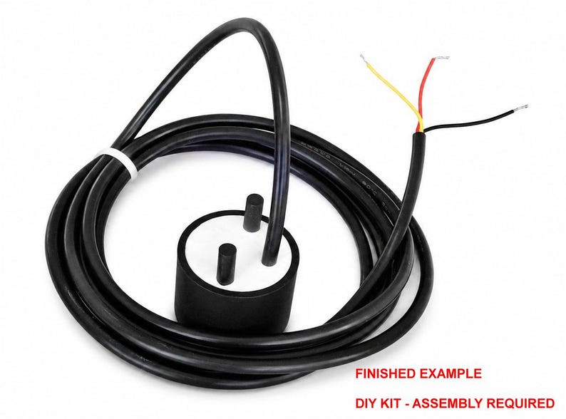 May include: A black cylindrical sensor with a white top featuring two protruding black pins, connected to a long black cable. The cable ends in three exposed wires colored yellow, red, and black. Text reads: FINISHED EXAMPLE DIY KIT - ASSEMBLY REQUIRED.