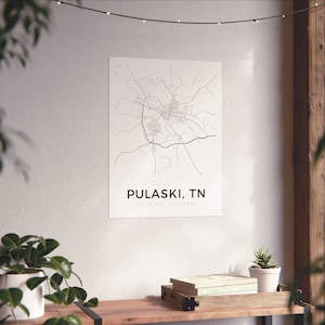 May include: A minimalist black and white map print of Pulaski, TN, displayed on a white wall. The print features a detailed road network and the city's name in a clean, modern font. The coordinates are also included. The print is part of a home decor collection.