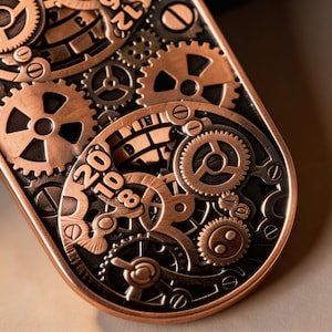 May include: Close-up of a steampunk-style metal object with intricate gear designs. The object features copper and dark gray tones, with visible numbers 8, 10, and 20. The gears are of various sizes and shapes, creating a complex mechanical aesthetic.