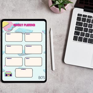 May include: A digital weekly planner with an 80s theme. The planner features a light blue background with retro graphics and the text "WEEKLY PLANNER". A white stylus and a laptop are next to the tablet. A small succulent plant in a pink pot is also visible.