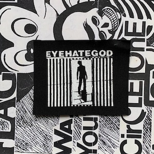 May include: Black patch with the text "EYEHATEGOD" above a white graphic of a person standing in front of vertical lines. The background is a black and white collage of text and abstract shapes.