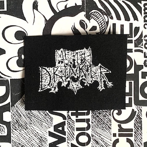 Może przedstawiać: Czarna prostokątna naszywka z białym napisem "METAL DRINKER" w gotyckiej czcionce. Naszywka znajduje się na tle czarno-białych wzorów graficznych.