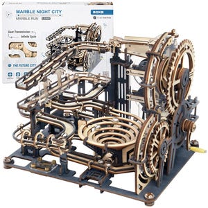 May include: A ROKR Marble Night City marble run model kit featuring a complex wooden gear transmission system with tracks, a spiral funnel, and a hand crank. The packaging box displays the product name, model number LGA01, and graphic illustrations.