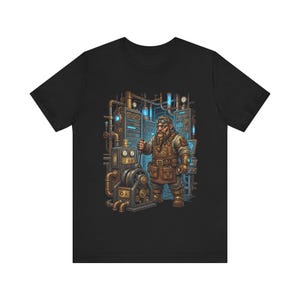 May include: Black t-shirt with a steampunk illustration. It shows a bearded dwarf in goggles and a leather apron, operating machinery with pipes and gauges. The artwork has a detailed, colourful design.