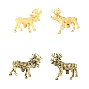 May include: Four metal cabinet knobs shaped like standing moose. Two knobs have a bright, polished gold finish, while the other two feature an antique brass finish with dark detailing. Each knob includes a cylindrical mounting post on the back.