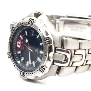 May include: A silver-toned Citizen Eco-Drive wristwatch with a dark blue circular dial, luminous hour markers, and a rotating bezel featuring engraved numbers. The watch includes a stainless steel link bracelet and is marked with WR 200.