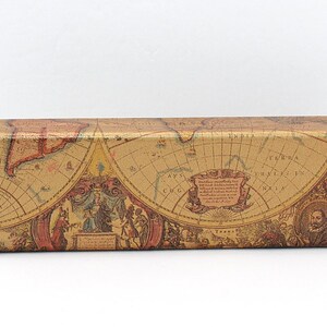May include: A rectangular eyeglasses case with a vintage map design. The case features a tan background with a detailed map print in shades of brown, red, and gold. The edges are black.