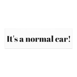 May include: A white rectangular sticker with the phrase "It's a normal car!" printed in bold, black letters. The text is centered on the sticker.