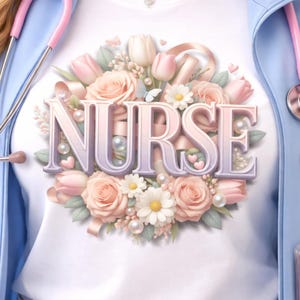 Könnte beinhalten: Weißes T-Shirt mit dem Wort "NURSE" in einer weichen Schriftart, umgeben von einem Blumenarrangement aus rosa Rosen, Tulpen und Gänseblümchen. Eine hellblaue Jacke und ein rosa Stethoskop sind ebenfalls zu sehen.