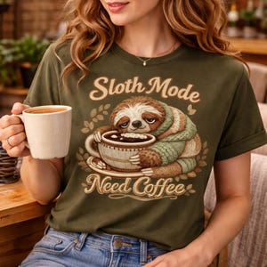 May include: A white ceramic mug with a black handle and the text "But First, Coffee" in a black, handwritten-style font. The mug is on a white surface.