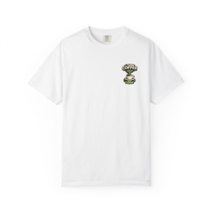 Può includere: T-shirt bianco con una piccola grafica sulla parte superiore sinistra del petto. La grafica presenta una tazza di caffè con la scritta "I TURN COFFEE CODE" in una combinazione di colori verde e marrone. La maglietta ha un girocollo e maniche corte.