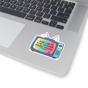 May include: A sticker featuring a retro television with a rainbow-colored screen. The text on the screen reads, "PLEASE STAND BY WE ARE EXPERIENCING EMOTIONAL DIFFICULTIES." The sticker is placed on a laptop.