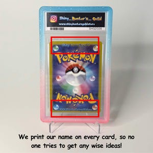 May include: A graded Pok&eacute;mon trading card encased in a blue and pink plastic slab. The card back features the Pok&eacute;mon logo, a central Pok&eacute; Ball graphic, and the text Shiny Hunter's Guild printed at the top and bottom within the card design.