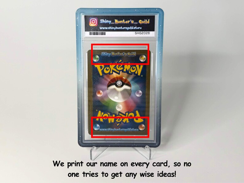 Op de afbeelding: Een gegradeerde Pok&eacute;mon-verzamelkaart in een doorzichtige plastic houder met een blauwe rand. De achterkant van de kaart toont het Pok&eacute;mon-logo en een centrale bol. Het label bevat de tekst Shiny_Hunter's_Guild en www.shinyhuntersguild.store.