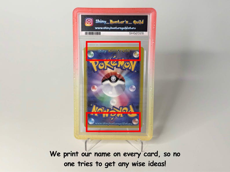 May include: A graded Pok&eacute;mon trading card encased in a clear plastic slab with a pink and yellow gradient border. The card features the classic blue back design with a central Pok&eacute; Ball and the text Shiny_Hunter's_Guild printed on the card surface.