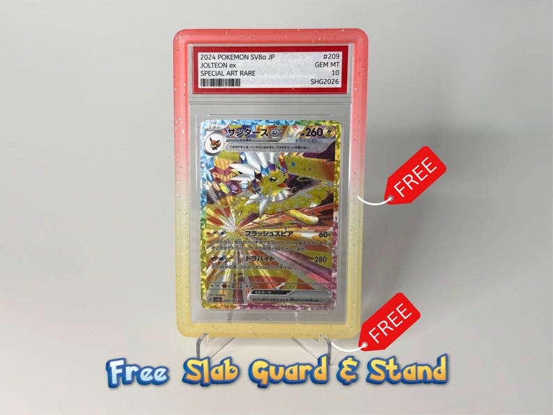 May include: A graded Jolteon ex trading card in a protective plastic slab with a pink and yellow gradient border. The card features Japanese text and artwork of the character. The slab is displayed on a clear plastic stand, and two red tags are attached.