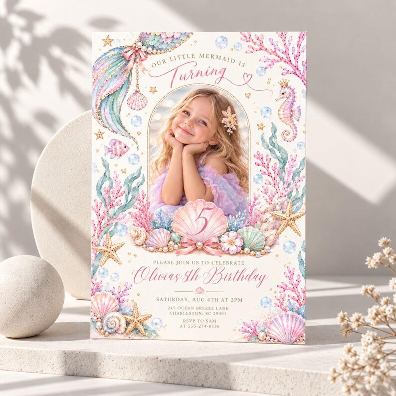 May include: A rectangular birthday invitation card featuring a central photo frame of a child, surrounded by watercolor illustrations of pink coral, seashells, starfish, a seahorse, and bubbles. Text includes Our Little Mermaid Is Turning 5, Olivia's 5th Birthday, and event details.