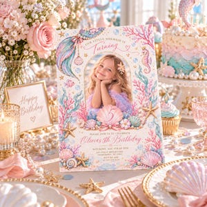 May include: A rectangular birthday invitation card featuring a central oval photo frame of a child, surrounded by watercolor illustrations of a mermaid tail, seahorse, starfish, seashells, and coral in pastel pink, blue, and gold tones with text.