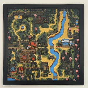 May include: A framed, colorful map illustration with a black border. The map features a winding blue river, roads, buildings, and trees in shades of green, yellow, red, and brown. The artwork has a cartoonish style.