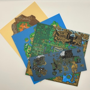 May include: A collection of colorful map prints, featuring detailed illustrations of landscapes with green forests, blue waters, and brown mountains. The maps are layered on top of each other, with a yellow background.