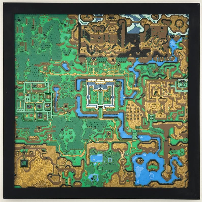 May include: A framed, colorful map of a fantasy world. The map features green forests, blue waterways, and gold-colored structures. The artwork is encased in a black frame, creating a striking visual contrast. The map's intricate details suggest a game or fictional setting.