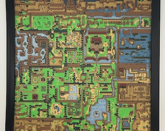 May include: A framed, colorful map of a video game world. The map features a detailed landscape with green fields, brown mountains, blue water, and various structures. The frame is black, and the overall aesthetic is reminiscent of a classic video game.
