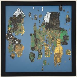 May include: Abstract art print in a black frame. The artwork features a map-like design with gold, green, black, white, and brown shapes on a blue background. The framed art is square and ready to hang.