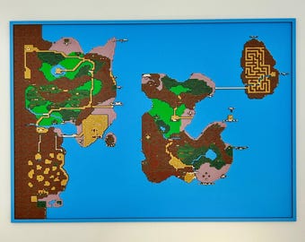 May include: A rectangular wall art piece featuring a pixelated map design with brown, green, and tan landmasses set against a bright blue background. The map displays various terrain features, including a maze section, all enclosed in a blue frame.