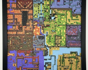 May include: A square wall art piece featuring a multi-colored pixelated map design enclosed in a black frame. The artwork displays a grid-like layout with distinct sections in orange, green, blue, and purple, resembling a top-down video game world.
