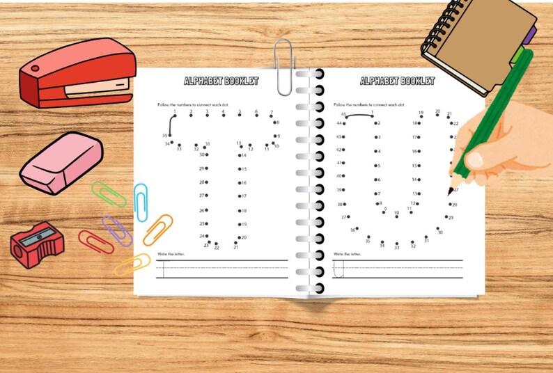 May include: An open spiral-bound alphabet booklet with the text "ALPHABET BOOKLET" is shown. A hand is holding a green pencil, connecting dots to form the letter "U". School supplies like a stapler, eraser, and paperclips are also visible.