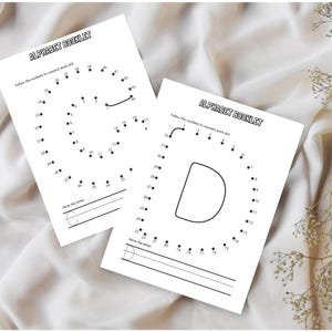 May include: Two white alphabet booklet pages with the text "ALPHABET BOOKLET". Each page features a letter formed by numbered dots, with lines for writing the letter. The letters are "G" and "D".