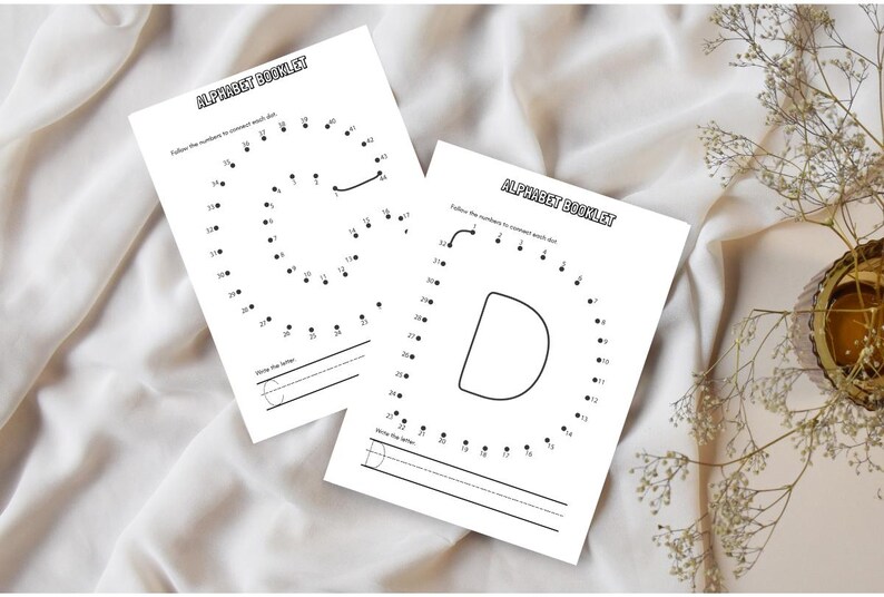 May include: Two white alphabet booklet pages with the text "ALPHABET BOOKLET". Each page features a letter formed by numbered dots, with lines for writing the letter. The letters are "G" and "D".