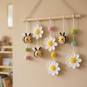 Peut inclure: Une décoration murale faite à la main avec des abeilles, des marguerites et des sphères colorées crochetées. Les abeilles sont jaunes et noires, les marguerites sont blanches avec des centres jaunes, et les sphères sont roses, jaunes et vertes.