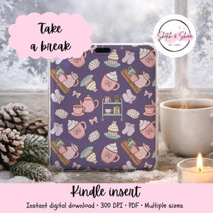 May include: A Kindle insert featuring a repeating pattern on a dark purple background. The design includes pink teapots, mugs with whipped cream, cupcakes, small bookshelves, and pairs of socks. The text "Take a break" appears in a pink cloud.