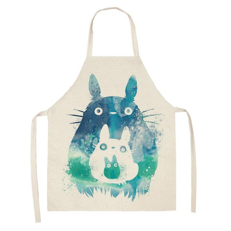 Puede incluir: Delantal beige con una ilustraci&oacute;n de acuarela de dos personajes de Totoro en tonos azules y verdes. El delantal tiene un lazo para el cuello y lazos en la cintura, ideal para la cocina.