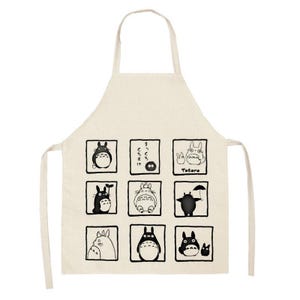 Puede incluir: Delantal beige con ilustraciones en blanco y negro de personajes de Totoro en marcos cuadrados. El delantal tiene un lazo para el cuello y lazos en la cintura. La palabra "Totoro" est&aacute; impresa en el delantal.