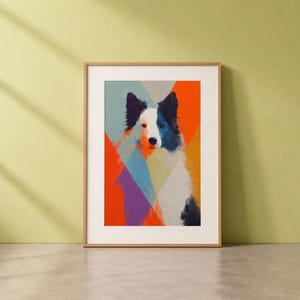 Op de afbeelding: Een ingelijste kunstdruk met een gestileerd hondenportret. De hond heeft een witte snuit, zwarte oren en een blauw oog, tegen een geometrische achtergrond van oranje, blauwe en paarse vormen. Het kunstwerk wordt op een lichtgekleurde muur getoond.
