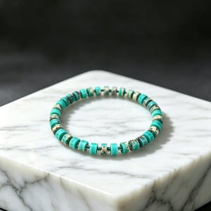 May include: A circular bracelet composed of small, disc-shaped beads in shades of turquoise blue and mottled brown. The beads are strung on a thin, dark-coloured cord, creating a uniform, repeating pattern of solid and speckled textures throughout.