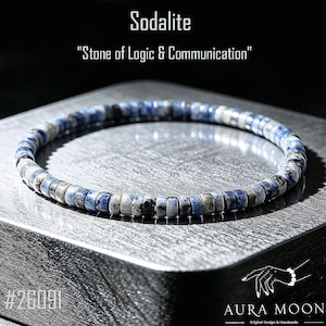 May include: A circular bracelet composed of small, disc-shaped sodalite beads in shades of blue, grey, and white. The text "Sodalite" and "Stone of Logic & Communication" appears above the bracelet, with "#26091" and "AURA MOON" below.