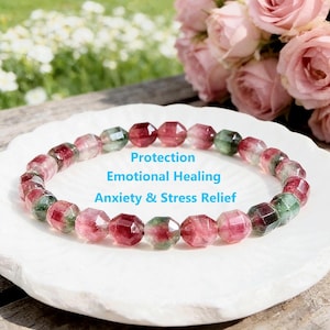Puede incluir: Un brazalete de turmalina sandía con cuentas facetadas en tonos rosa, rojo y verde. El brazalete se muestra sobre un plato blanco. El texto en la imagen dice "Protection, Emotional Healing, Anxiety & Stress Relief."