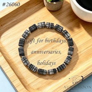 May include: A black and white striped bead bracelet. The bracelet is displayed on a wooden tray with the text "Gift for birthdays, anniversaries, holidays". A gift idea.