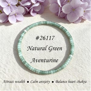 May include: A circular bracelet made of small, square, light green aventurine beads. The text #26117 Natural Green Aventurine is centered inside the circle, with the text Attract wealth • Calm anxiety • Balance heart chakra below.