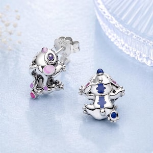 Peut inclure: Une paire de boucles d'oreilles &agrave; clous en argent en forme de petites cr&eacute;atures aux surfaces m&eacute;talliques polies. Une boucle pr&eacute;sente des accents en &eacute;mail rose et violet, tandis que l'autre affiche des d&eacute;tails en &eacute;mail bleu et violet. Marquage S925.