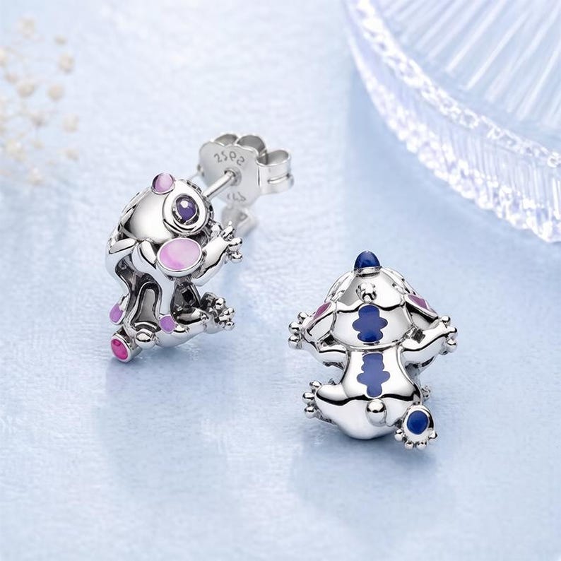 Peut inclure: Une paire de boucles d'oreilles &agrave; clous en argent en forme de petites cr&eacute;atures aux surfaces m&eacute;talliques polies. Une boucle pr&eacute;sente des accents en &eacute;mail rose et violet, tandis que l'autre affiche des d&eacute;tails en &eacute;mail bleu et violet. Marquage S925.
