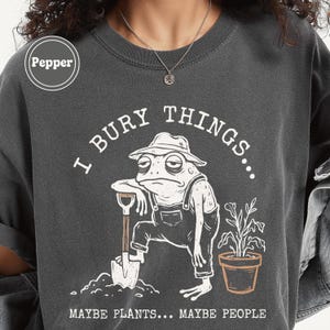 May include: A white ceramic mug with a black handle and the text "But First, Coffee" in a bold, black font. The mug is set against a blurred background, suggesting a cozy setting.