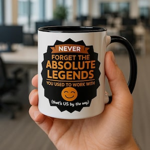 Può includere: Tazza in ceramica bianca con manico e bordo neri. La tazza presenta il testo "NEVER FORGET THE ABSOLUTE LEGENDS YOU USED TO WORK WITH" in arancione e nero. Un'emoticona sorridente è sotto, con la frase "(that's US by the way)" in basso.