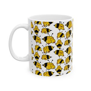 Può includere: Tazza in ceramica bianca con un motivo ripetuto di api dei cartoni animati in giallo e nero. Le api hanno facce sorridenti e sono in varie pose. La tazza ha un manico e un interno bianchi.